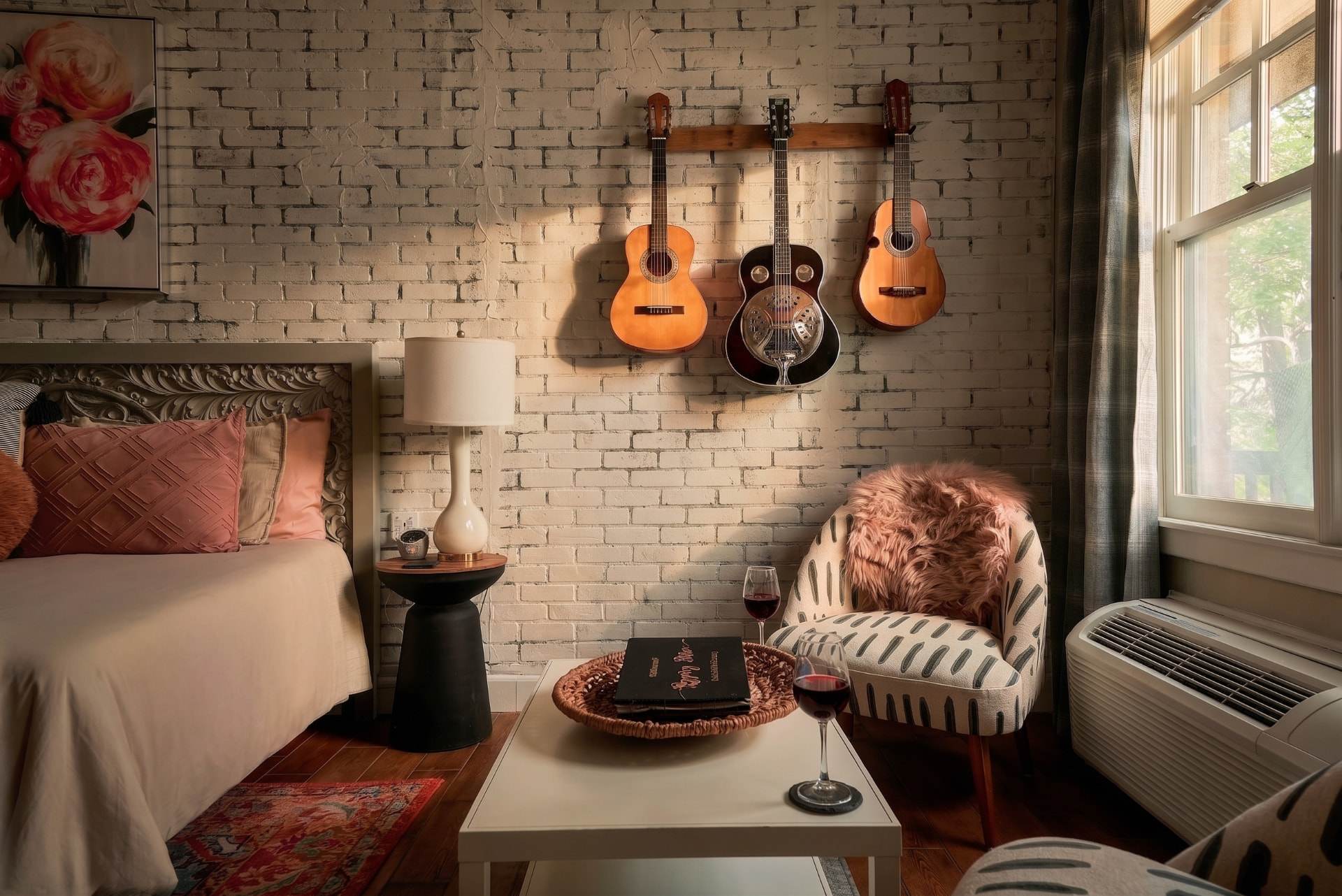 Warm vacation rental bedroom with guitars hung above a styled seating area